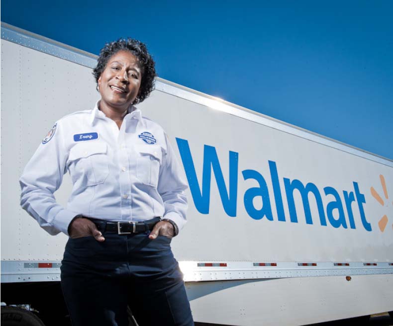 A Walmart fleet driver poses next to Walmart truck.