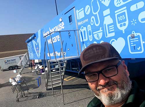 Man standing in front of a Walmart Pharmacy trailer