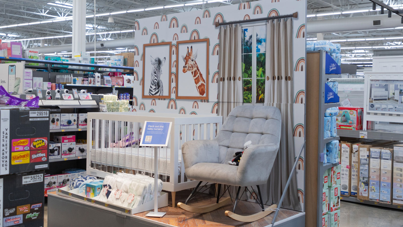 Nursery decor display in store home department showing crib, bedding and rocking chair.