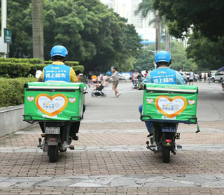Two people driving bikes with deliver packages on the back