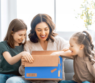 A smiling woman and children open a Walmart box