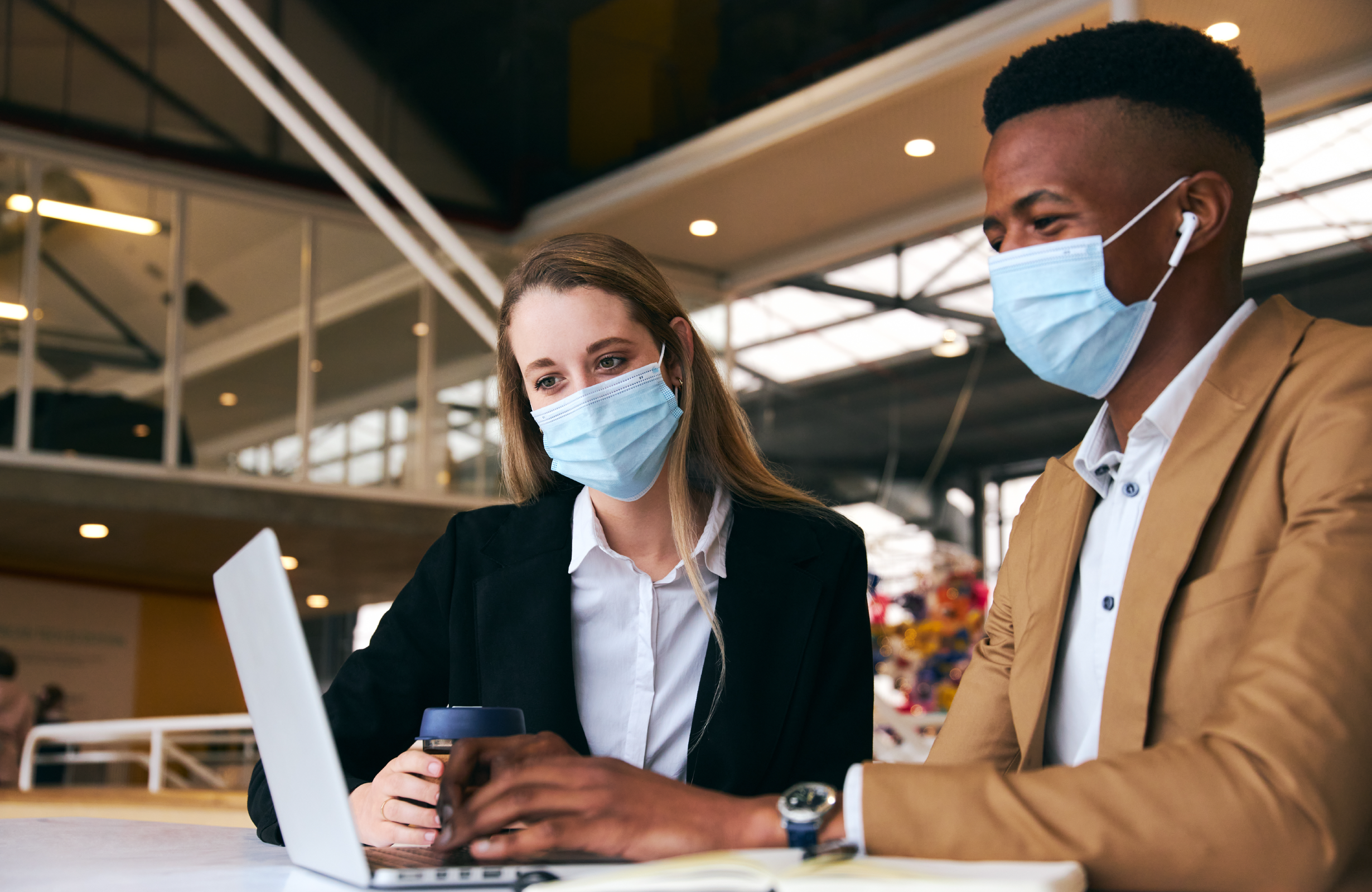 Suppliers wearing masks while working on computer