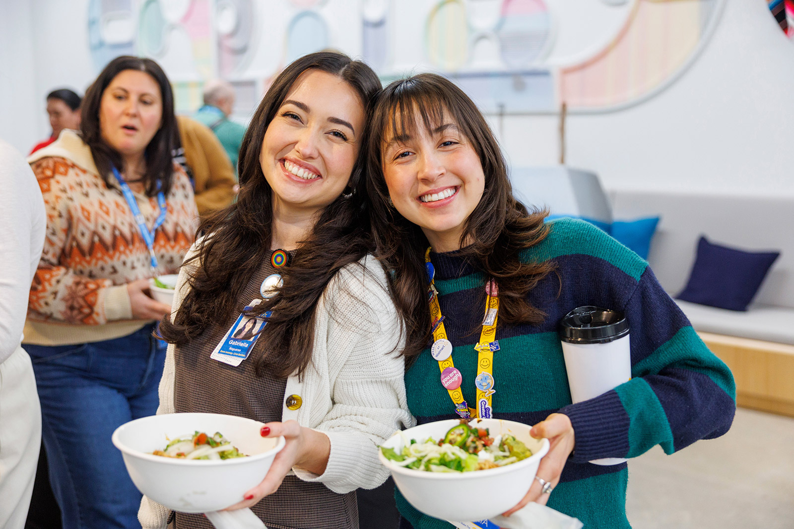 A photo of two Walmart associates holding a bowl of salad and smiling as they pose for a photo.